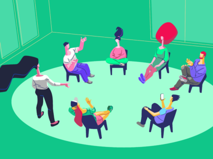 People sitting in a circle having a discussion in a brightly colored room.