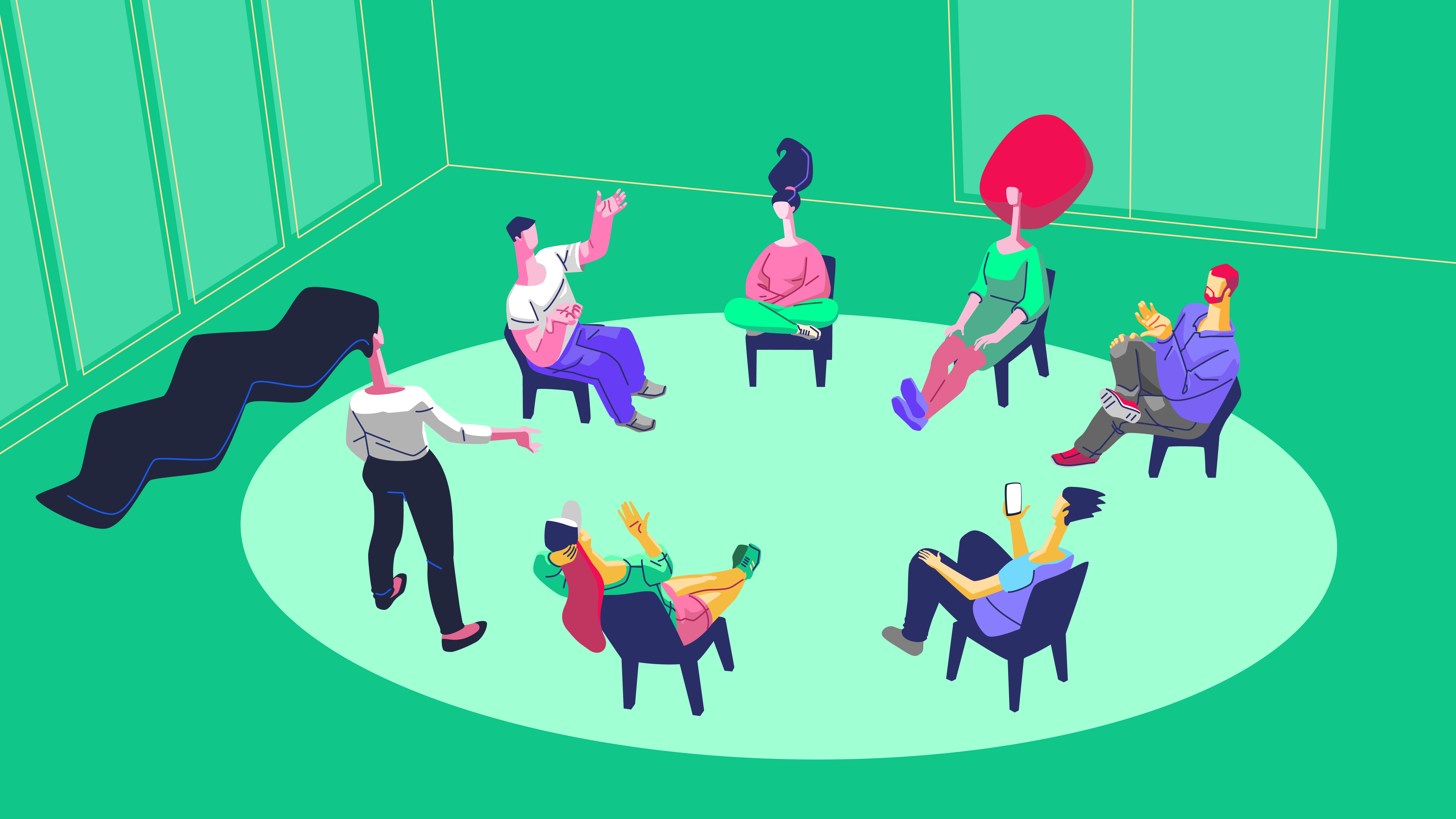 People sitting in a circle having a discussion in a brightly colored room.